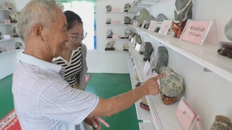 王學舜正在介紹他收藏的石頭。
